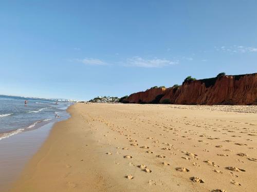 a beach with footprints in the sand and the ocean at Beach Villa Vale do Lobo in Vale do Lobo