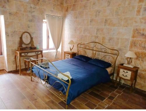 a bedroom with a bed with a blue comforter at Perimenis Seaside House in Gerolimenas