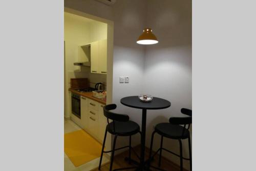 una piccola cucina con tavolo e sgabelli di Entire guest suite a San Giuliano