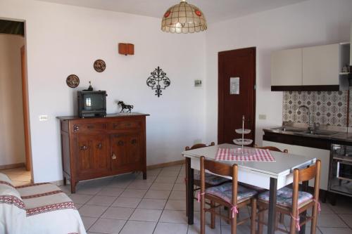 cocina y comedor con mesa y sillas en Casa Miclara - Bilocale "Limoni" en Zanca