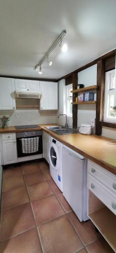 a kitchen with a sink and a washing machine at Orchard Cottage in Salisbury
