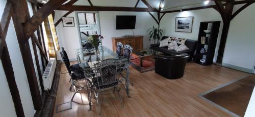 a living room with a glass table and chairs at Orchard Cottage in Salisbury