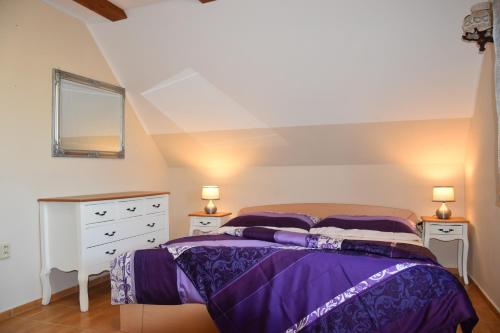 a bedroom with a purple bed and two night stands at Chalupa Rekreant in Bešeňová