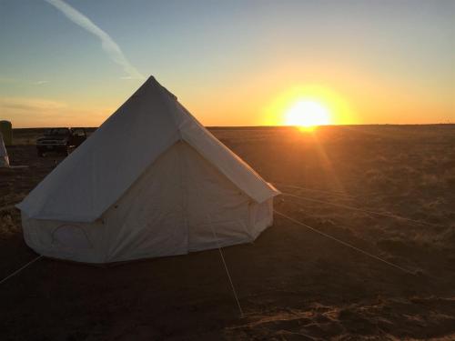 a tent in a field with the sunset in the background at Starlight Tent 2 in Holbrook