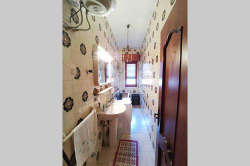 a bathroom with a sink and a mirror at Comodo appartamento in zona centrale e strategica. in Lamezia Terme