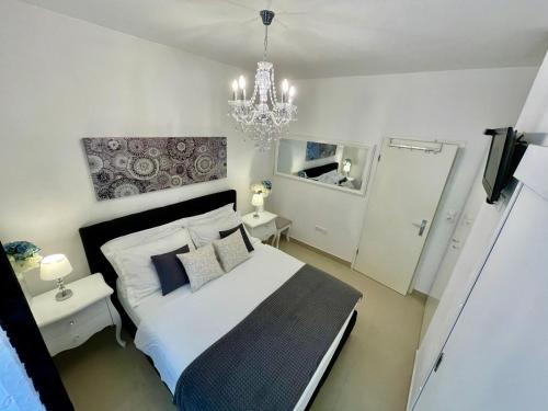 sypialnia z łóżkiem i żyrandolem w obiekcie Central Square Guest House w mieście Zadar