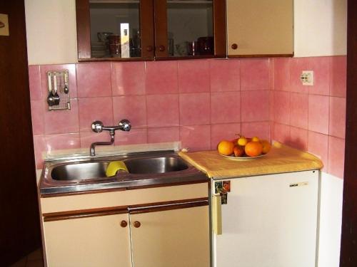 a kitchen with a sink and a bowl of fruit at Apartment in Pakoštane with sea view, balcony, WiFi (3539-2) in Pakoštane