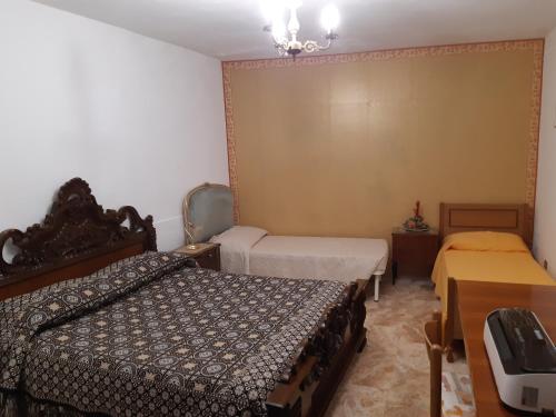 a small bedroom with two beds and a table and a bed sqor at Affittacamere da Angela in Borgorose