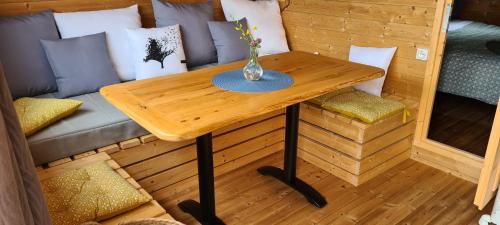 Hébergements insolites - Détente en Luberon في Viens: طاولة خشبية مع مزهرية فوق أريكة
