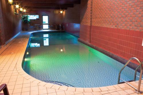 a swimming pool with green water in a building at The Royal Lion Hotel in Lyme Regis