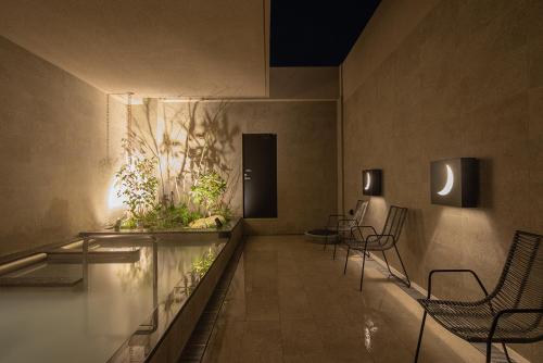 a lobby with chairs and plants on the wall at hotel H2 TRIP&BUSINESS NAGASAKI in Nagasaki