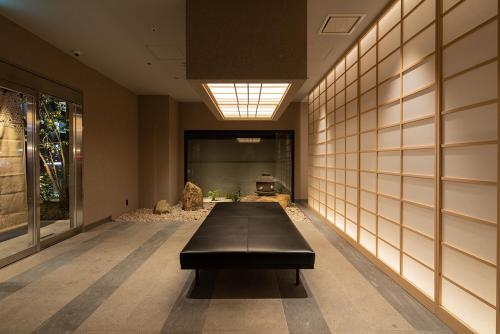 a hallway with a black bench in a building at hotel H2 TRIP&BUSINESS NAGASAKI in Nagasaki