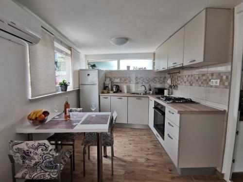 a kitchen with white appliances and a table with chairs at Apartment Maja in Bribir