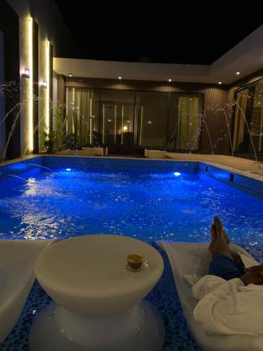 a hotel swimming pool with a person laying in a tub at منتجع ويستن Westin Chalet in Taif