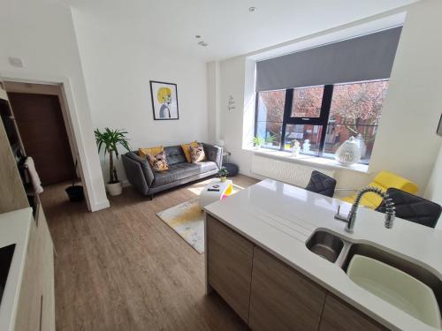 eine Küche und ein Wohnzimmer mit einem Sofa in der Unterkunft 34 Cuppin Street - luxury city centre apartment! in Chester