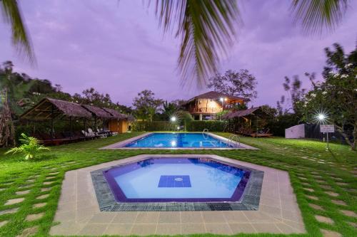 a swimming pool in a yard with a house at The Hideout Sigiriya in Sigiriya