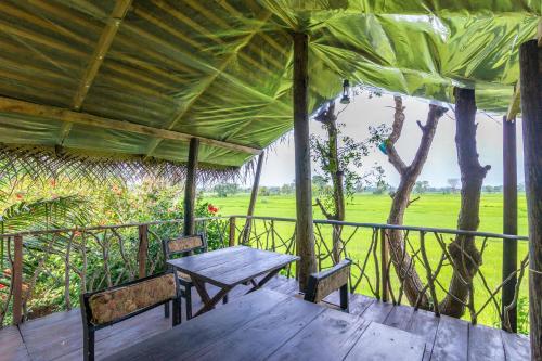 a wooden porch with a table and two chairs at The Hideout Sigiriya in Sigiriya