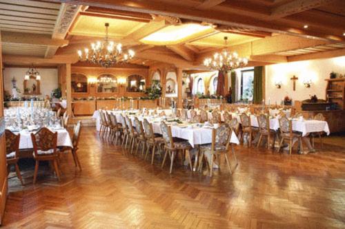 een feestzaal met witte tafels en stoelen en kroonluchters bij Hotel Rhönhof in Oberleichtersbach