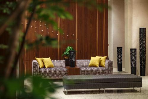Dois sofás com almofadas amarelas no átrio em Hotel Vista Sendai em Sendai