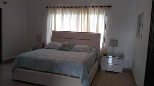 a bedroom with a large bed and a window at White House Mansion in San Felipe de Puerto Plata