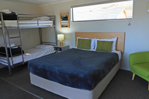 a bedroom with two bunk beds and a couch at Lakes Edge Holiday Park in Lake Tekapo