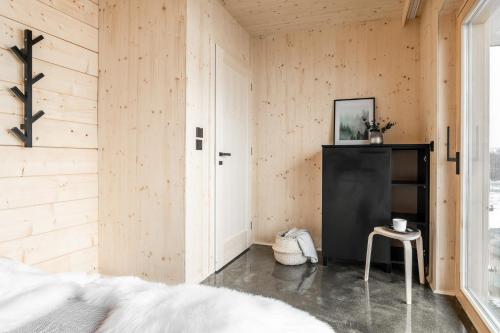 畢奧卡塔柴斯卡的住宿－Mleko Domki apartamenty，卧室设有木墙、一张床和凳子