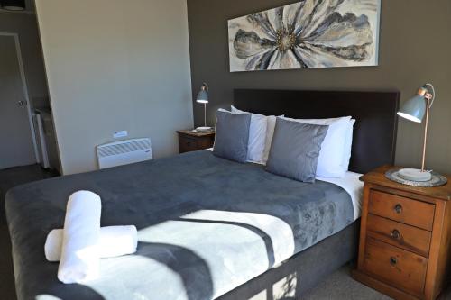 a bedroom with a large bed with a chair on it at Lakes Edge Holiday Park in Lake Tekapo