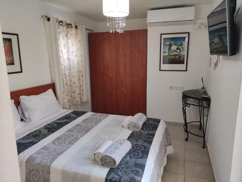 um quarto com uma cama com toalhas em Eden's Sweet Place em Eilat