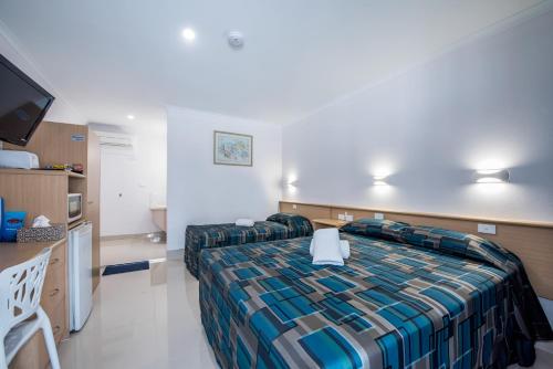 een hotelkamer met een bed en een flatscreen-tv bij Casa Nostra Motel Mackay in Mackay