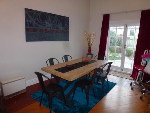 a dining room with a wooden table and chairs at Old world charm in town and by the sea in Napier
