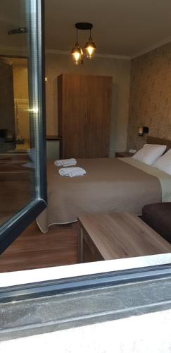a hotel room with two beds and a table at Vaso&Iro Guest House in Borjomi