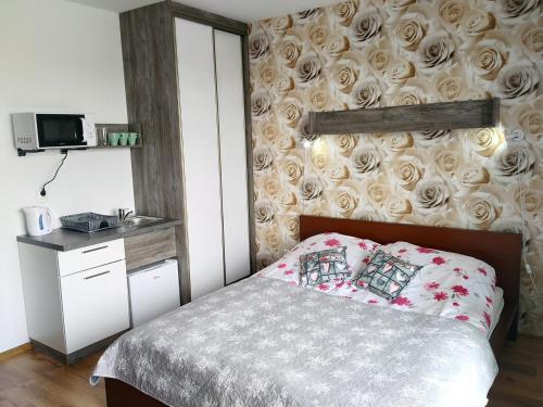 een slaapkamer met een bed en een muur met rozen bij Villa Over Lake in Mielno