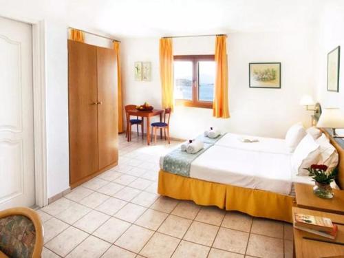 una habitación de hotel con una cama grande y una mesa en Fiorella Sea View, en Megali Ammos