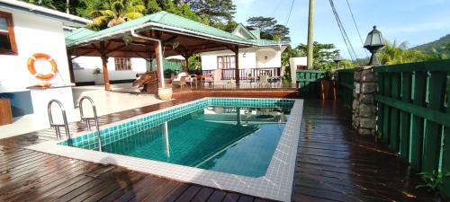 a swimming pool on a deck with a house at Chalets Des Vacances in Takamaka