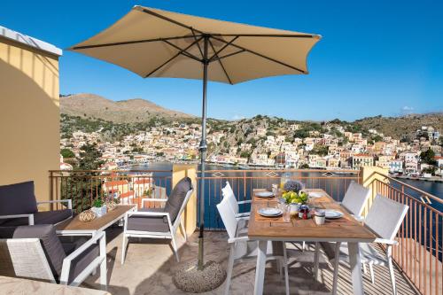 un patio con mesa y sombrilla en Sea La Vie Villa Symi, en Symi