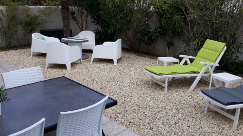 un groupe de chaises, une table et des chaises dans l'établissement Villa Moris, à Dolus-d'Oléron