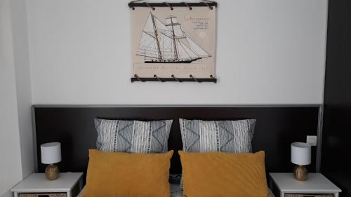 Zimmer mit zwei Kissen und einem Bild eines Schiffes in der Unterkunft Villa Moris in Dolus d'Oléron