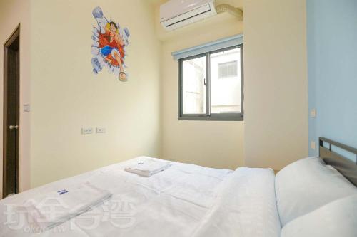a white bed in a room with a window at 築夢居民宿 in Magong