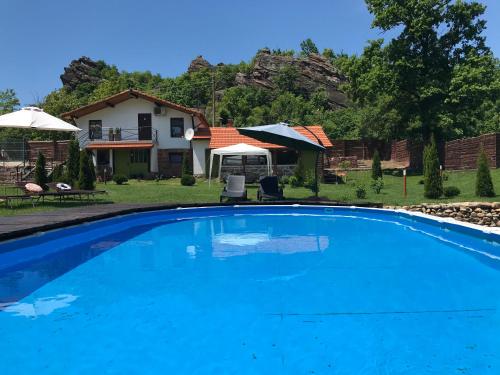 a large blue swimming pool in front of a house at Villa Garden in Falkovets