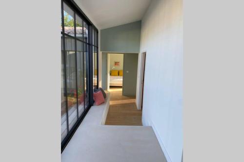 a hallway of a house with glass doors at Elégante maison d'architecte, Spa à débordement in La Noue