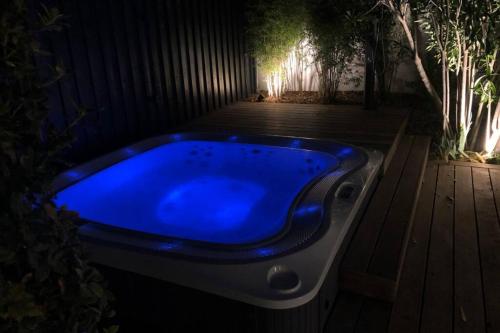 a blue bath tub sitting on a wooden deck at Elégante maison d'architecte, Spa à débordement in La Noue