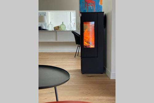 a living room with a black refrigerator and a table at Elégante maison d'architecte, Spa à débordement in La Noue