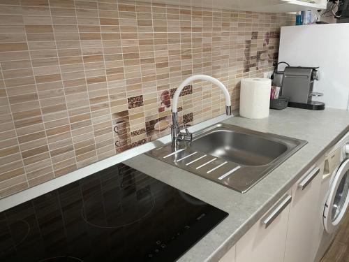 a kitchen counter with a sink and a refrigerator at ConfortMax in Baia Mare