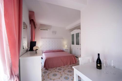 a bedroom with a bed and a table with a bottle of wine at Hotel Residence Villa San Giovanni in Portoferraio
