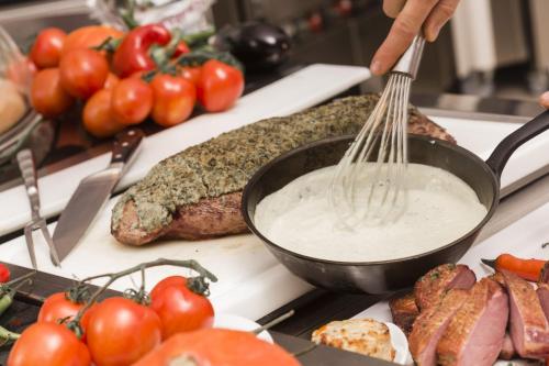 a person stirring a wok with tongs over some food at René Bohn in Ludwigshafen am Rhein