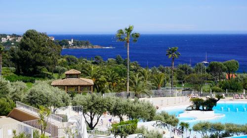 a view of a resort with a swimming pool and the ocean at Appartement 174, Vue mer à Cap Esterel By Palmazur in Saint-Raphaël