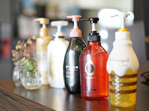 a row of different bottles sitting on a table at Hotel AreaOne Takamatsu in Takamatsu