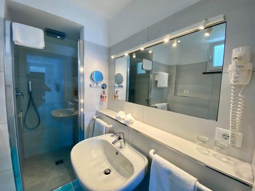 a bathroom with a sink and a shower and a mirror at Hotel Casa Sofia in Ischia