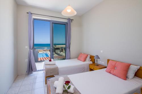 a bedroom with two beds and a view of the ocean at Giannarakis Beach in Stalos