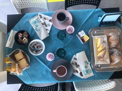 a blue table with breakfast foods and coffee on it at B&B Dionea in Santa Maria di Castellabate